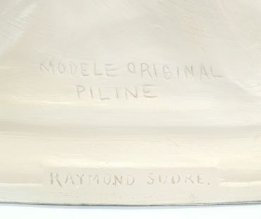 Inscription on a light-colored surface reading 'MODELE ORIGINAL PILINE RAYMOND SUDRE.'