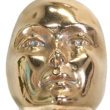 A shiny golden sculpture of a human head and neck on a square base.