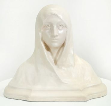 White marble bust of a woman with a serene expression and draped hood.