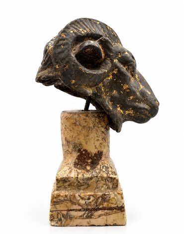 Bronze ram head sculpture on marble base, left-profile view with curled horn