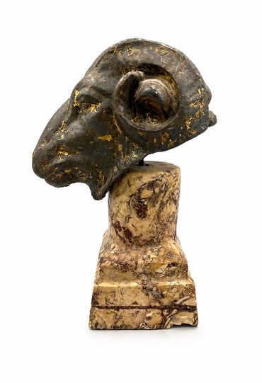 Bronze ram head sculpture on marble base, right-profile view with curled horn
