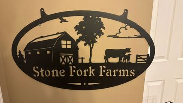 Metal farm sign with barn, tree, cow, and text 'Stone Fork Farms'.