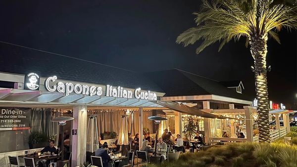 Exterior night picture of Capone’s Italian Cucina showing outdoor dining.