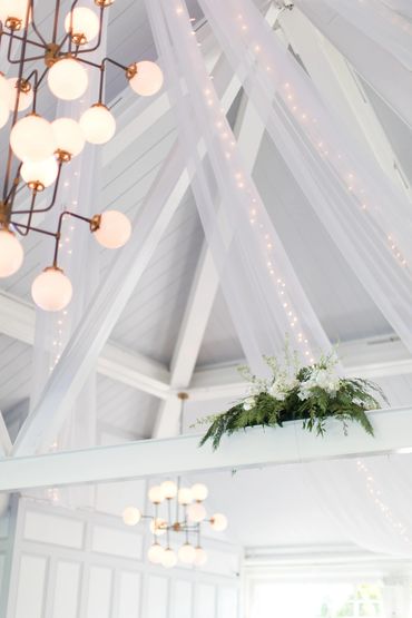 Material draping with lights + Greenery and flowers on beams