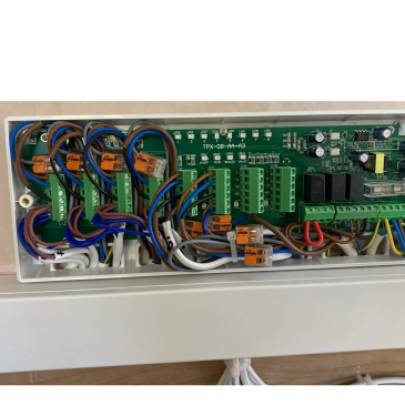 Circuit board with organized wiring inside a white enclosure.