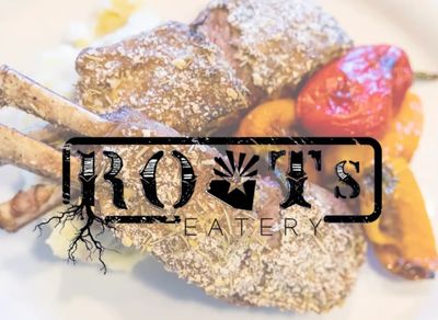 Close-up of breaded lamb chops with roasted vegetables.