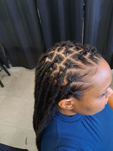 Close-up of intricately styled dreadlocks on a woman's head.