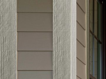Close-up of house exterior showing siding and window frame.