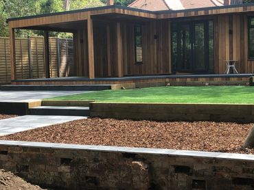 Paving sleepers artificial grass play area bark studio garden studio cedar cabin garden design Kew