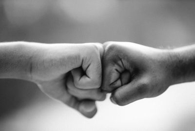 A photo of two men fist bumping one another.