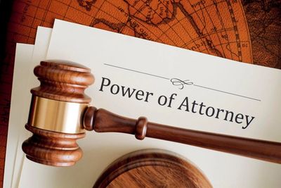 A gavel on a table with power of attorney document.