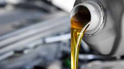 Fresh oil being poured into an engine during an oil change.