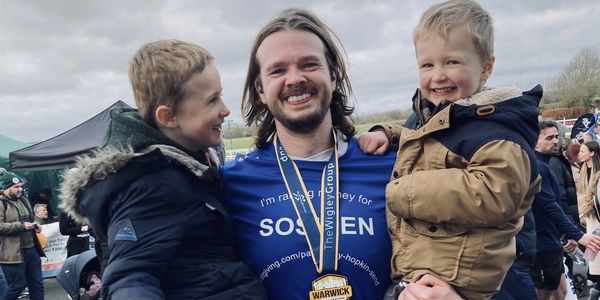 Man with two children celebrating a race finish.