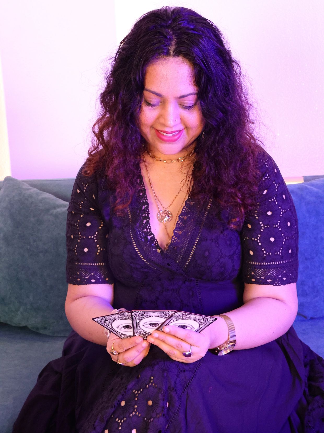 Woman in a black dress holding a fan of cards.