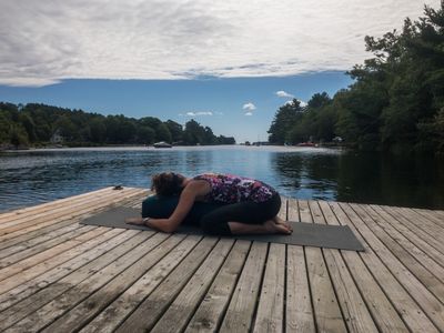 Woman doing yoga pose on dock at Yoga Retreat of River Ridge Lodge, a Mahone Bay Bed and Breakfast