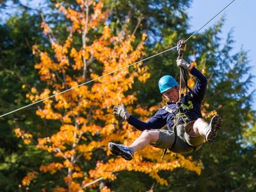 Man in shorts ziplining at Ontree Climbing and Ziplining near Windsor, Nova Scotia near South Shore
