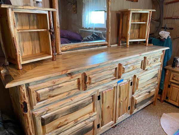 Rustic wooden dresser with mirror and small shelves.