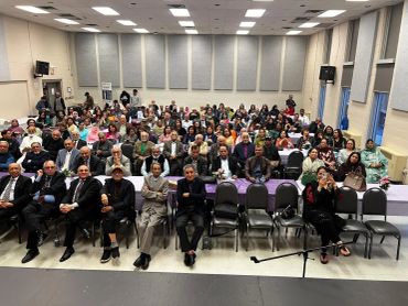 Large group of people seated in a hall.