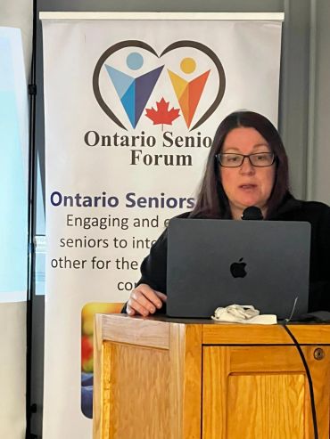Woman speaking at Ontario Senior Forum podium.