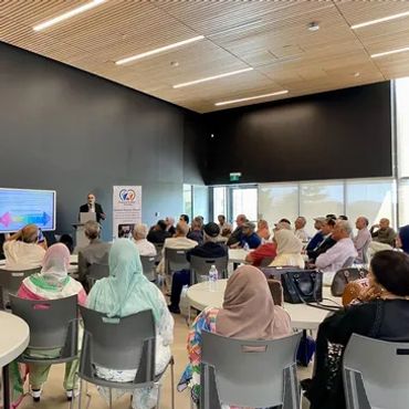 Audience listening to a speaker at an indoor event.