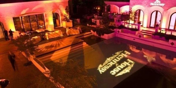 Elegant outdoor evening event with warm lighting and pool projection.