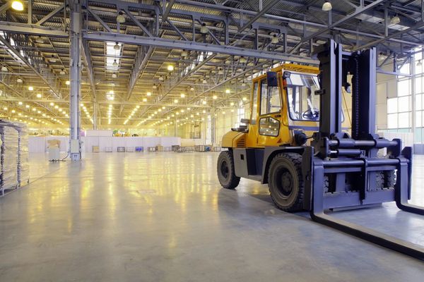 A large yellow forklift parked in a warehouse