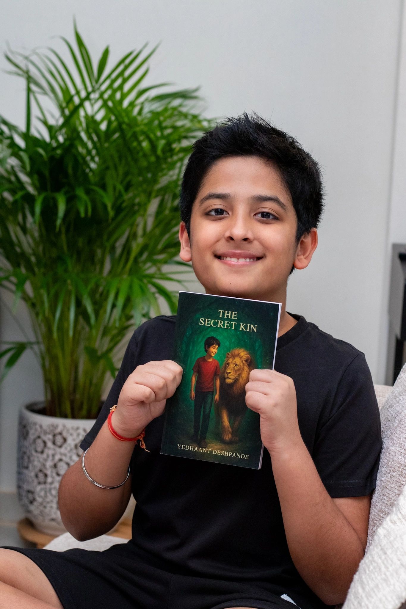 Children's author Yedhaant Deshpande happily holding his book The Secret Kin