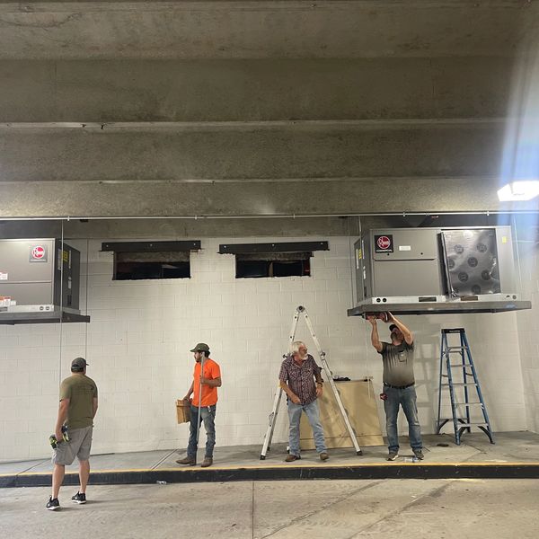 Porter Heating & Cooling employees installing commercial HVAC