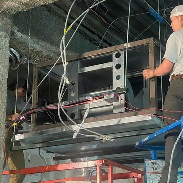 Porter Heating & Cooling employees installing commercial air conditioning unit