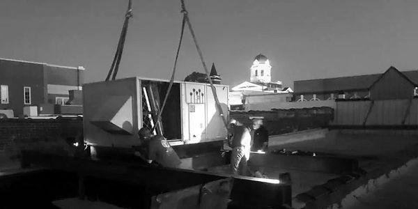 Porter Heating & Cooling employees installing commercial air conditioning unit