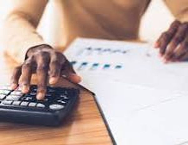 Person using a calculator and reviewing charts on paper.