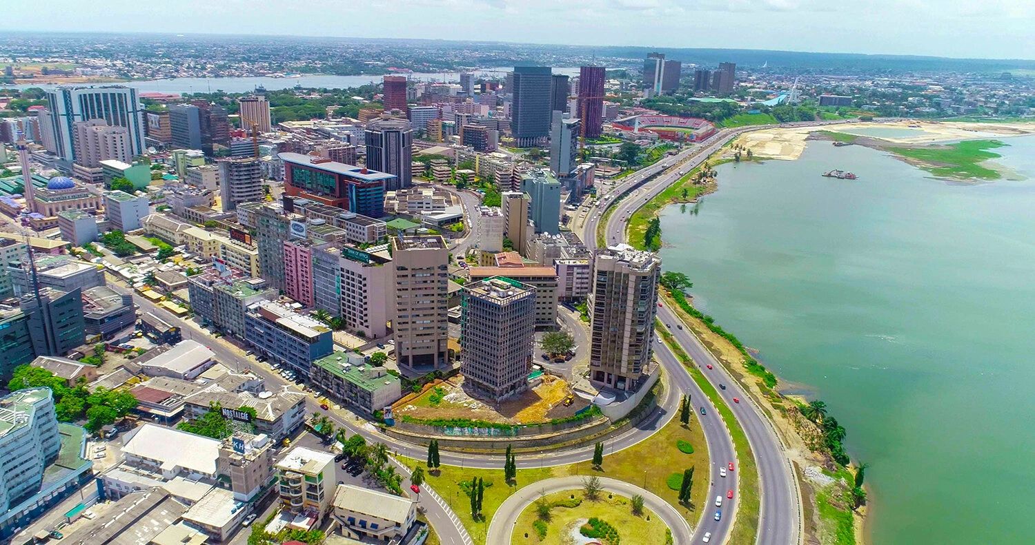Aerial view of a city with tall buildings and a waterfront highway.
