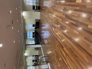 Spacious dance studio with wooden floors and mirrored wall.