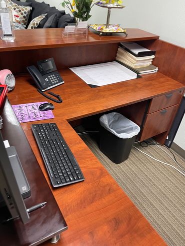 Organized office desk with computer, phone, and files.