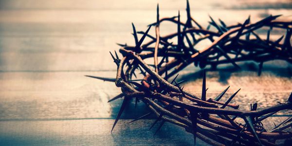 A crown of thorns resting on a wooden surface.