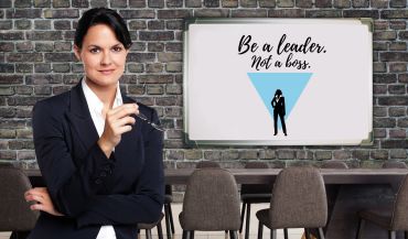 Confident businesswoman in front of a motivating leadership quote on a whiteboard.