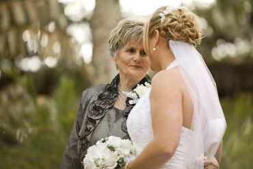 Bride sharing a tender moment with an elderly woman at a wedding.
