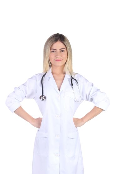 Confident female doctor in white coat with stethoscope, hands on hips.