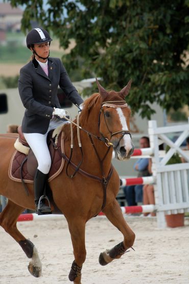 A female equestrian riding a horse during a competition.