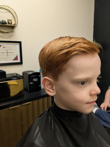 Young boy with neatly styled red hair after a haircut.