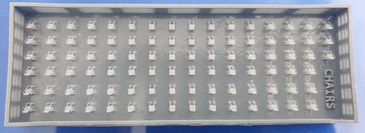 A tray with multiple small white chair models arranged in rows.