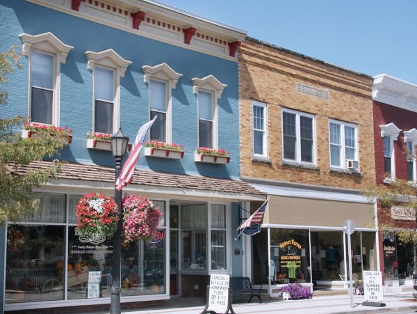 Sunny day on a quaint main street with colorful buildings and flags.