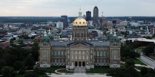 The Iowa State Capitol with its golden dome in Des Moines cityscape.