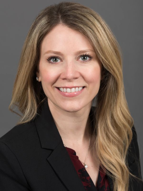 Professional woman smiling in business attire.