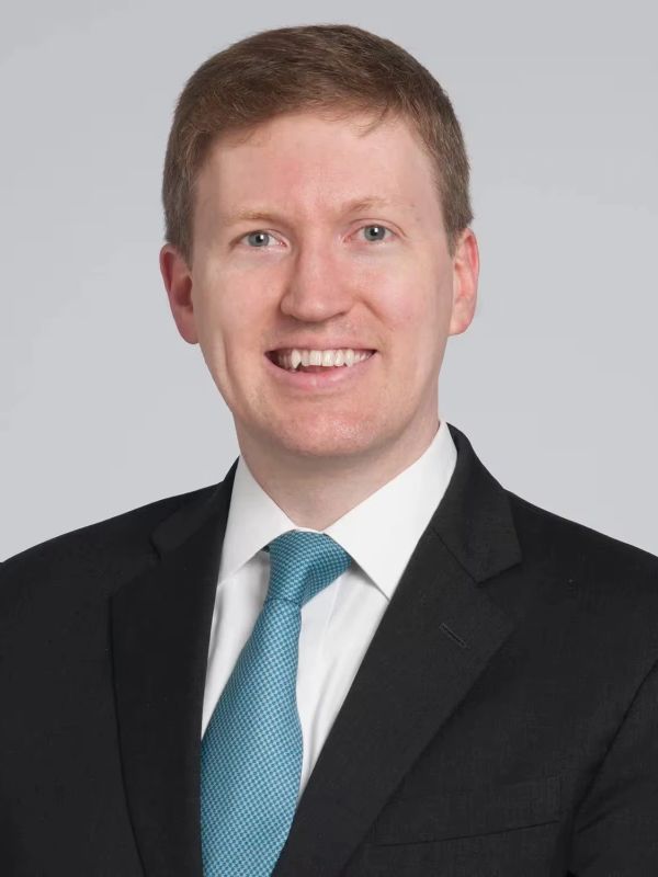 Professional man in suit and blue tie smiling.