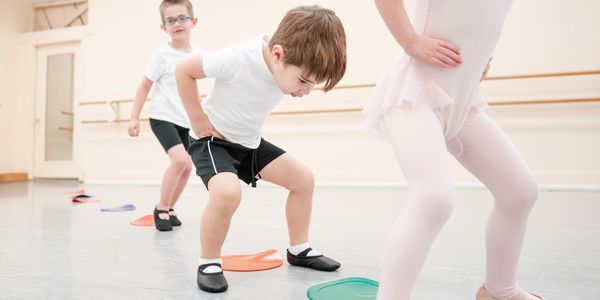 Young dancers jumping on dots in class