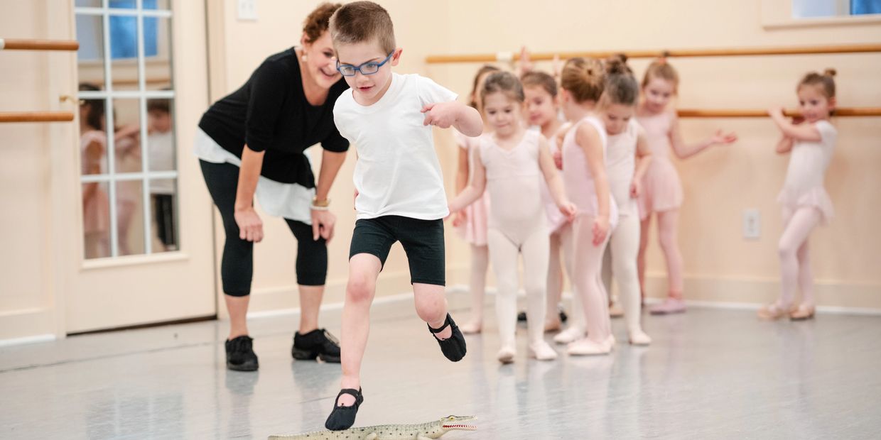 Young dancer jumping over an alligator in class