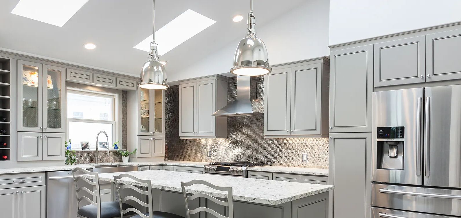 Bright modern kitchen with gray cabinetry and stainless steel appliances.
