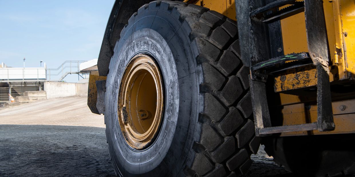 Close up shot of the front wheel of a digger at a building site.