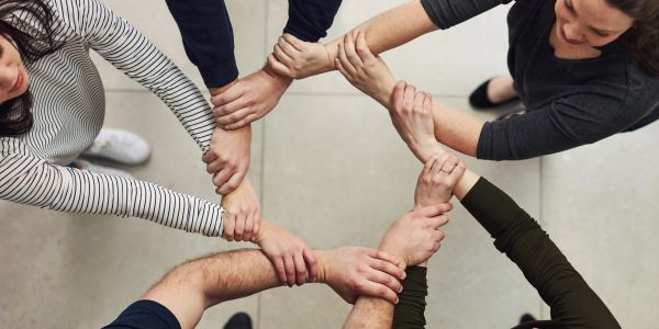 People holding each other's wrists in a circle.